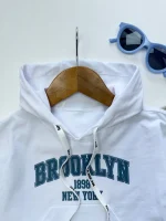نمای نزدیک از لوگو BROOKLYN روی سینه تاپ بچگانه