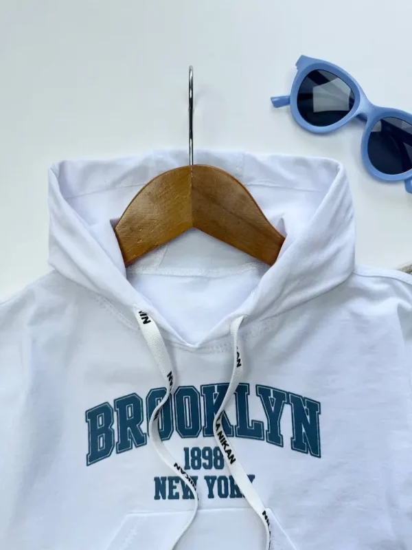 نمای نزدیک از لوگو BROOKLYN روی سینه تاپ بچگانه